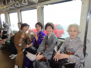 江ノ電車中 雨に煙る江ノ島の海を背景に